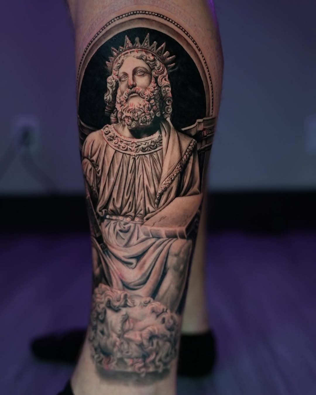 Black and grey religious king statue with crown and halo tattoo on leg by Ink Theory
